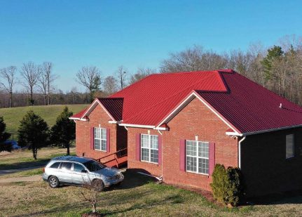 Red metal roof on a brick home