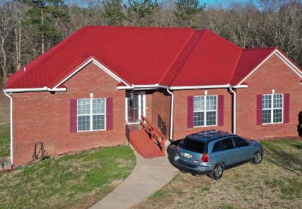 Red metal roof on a brick home
